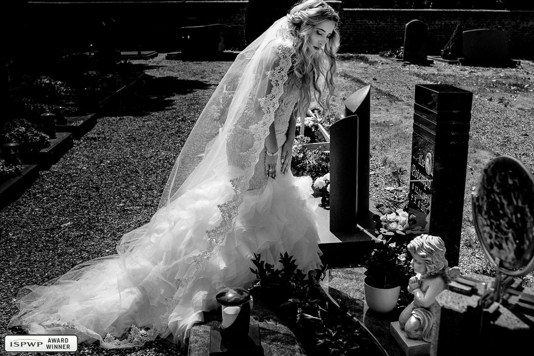 Braut steht bei ihrer Hochzeit am Grab ihrer Oma.